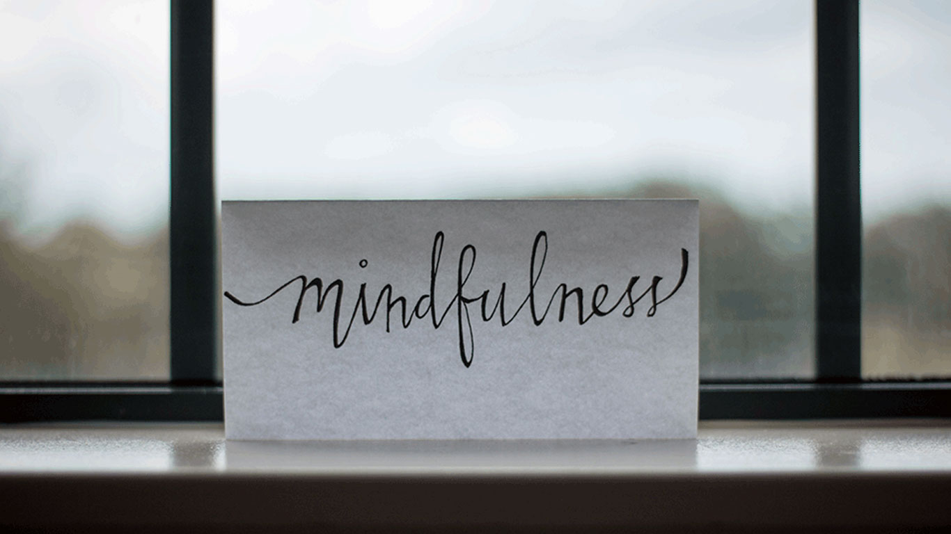 Ein Schild mit der Schrift "Mindfulness". Durch Transzendentale Meditation besser auf sich selber achten