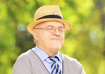Ein glücklicher alter Mann mit Hut und geschlossenen Augen