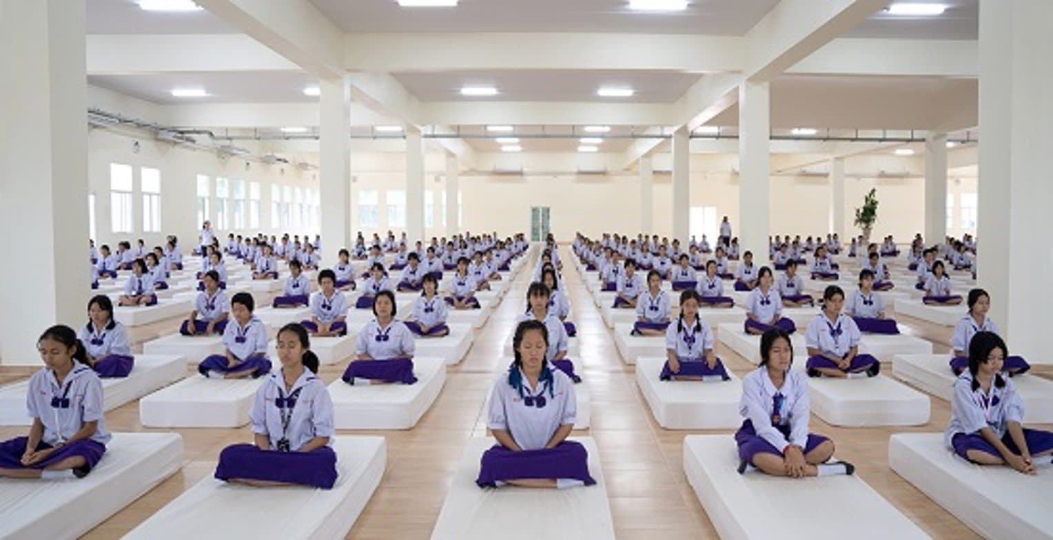 Thailändische Schülerinnen praktizieren in der Gruppe Transzendentale Meditation in der Meditationshalle