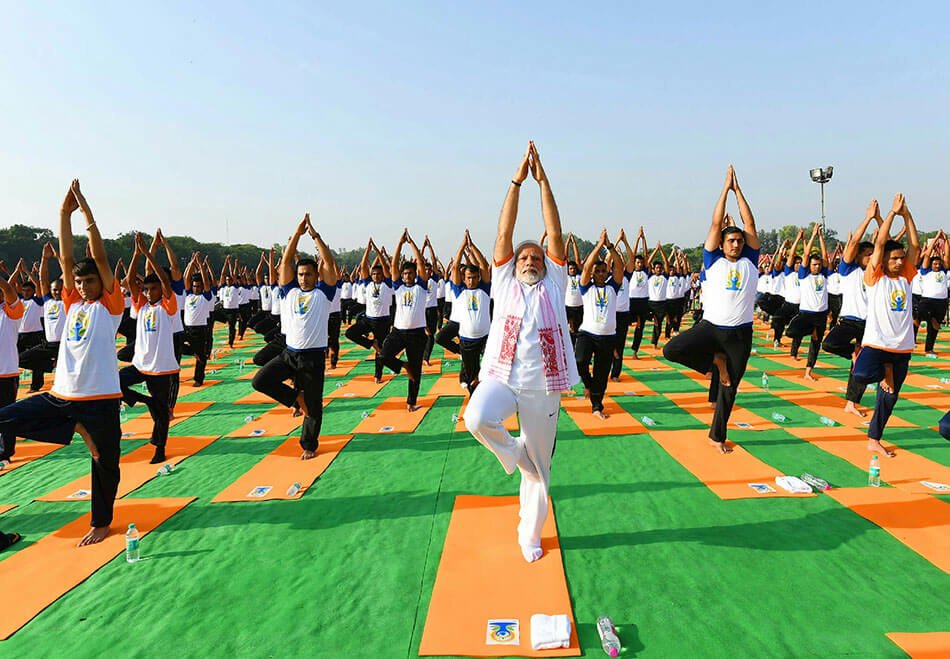 Eine Gruppe praktiziert Yogaübungen am Weltyogatag 2019. In der Mitte der indische Premierminister Narendra Modi.